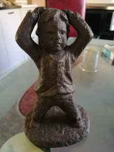 Skulptura dječaka u glini